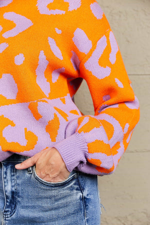 Colorblock leopard print acrylic sweater with balloon sleeves in orange and lavender.