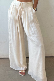 White pleated linen palazzo trousers with drawstring waist and pockets
