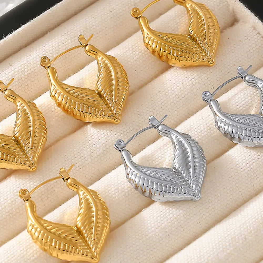 Textured gold leaf hoop earrings in gold and silver finishes.