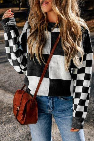 Colorblock checkerboard knit sweater in black and white with crew neck and long sleeves.