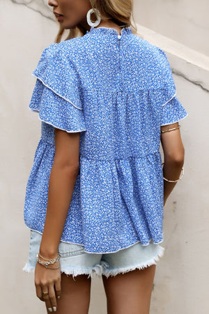 Sky blue floral peplum blouse with ruffled tiers and white trim, high neckline.