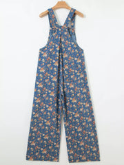 Floral denim overalls with adjustable straps and wide legs.