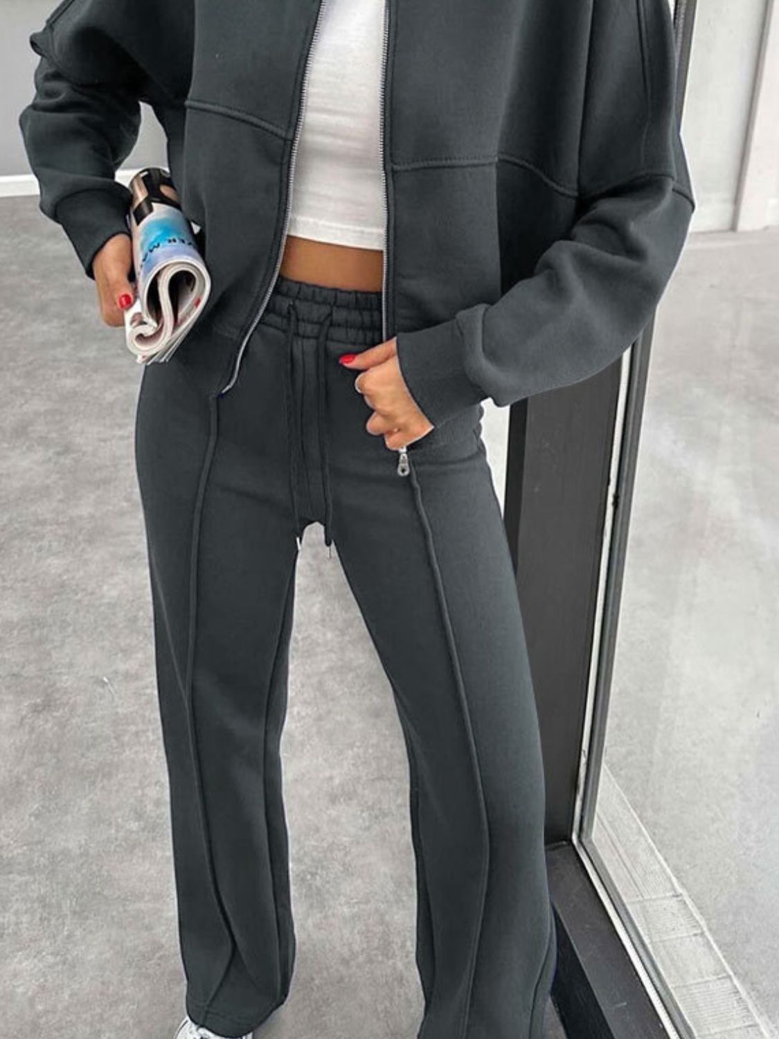 Dark gray bomber jacket and wide-leg tracksuit with drawstring waist and zippered pockets.
