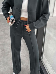 Dark gray bomber jacket and wide-leg tracksuit with drawstring waist and zippered pockets.