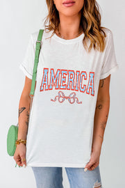 White graphic tee with "AMERICA" text and a bow detail.