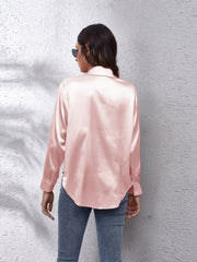 Silken button-down shirt in blush pink with a relaxed fit and button cuffs.