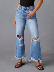 Chic distressed blue denim maternity flare jeans with raw hem and knee rips.