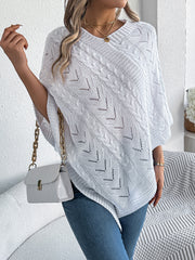 White cable knit poncho with chevron detail and V-neck, styled with a white crossbody bag.