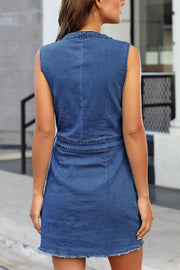 Medium wash denim button-down mini dress with pockets and frayed hem.