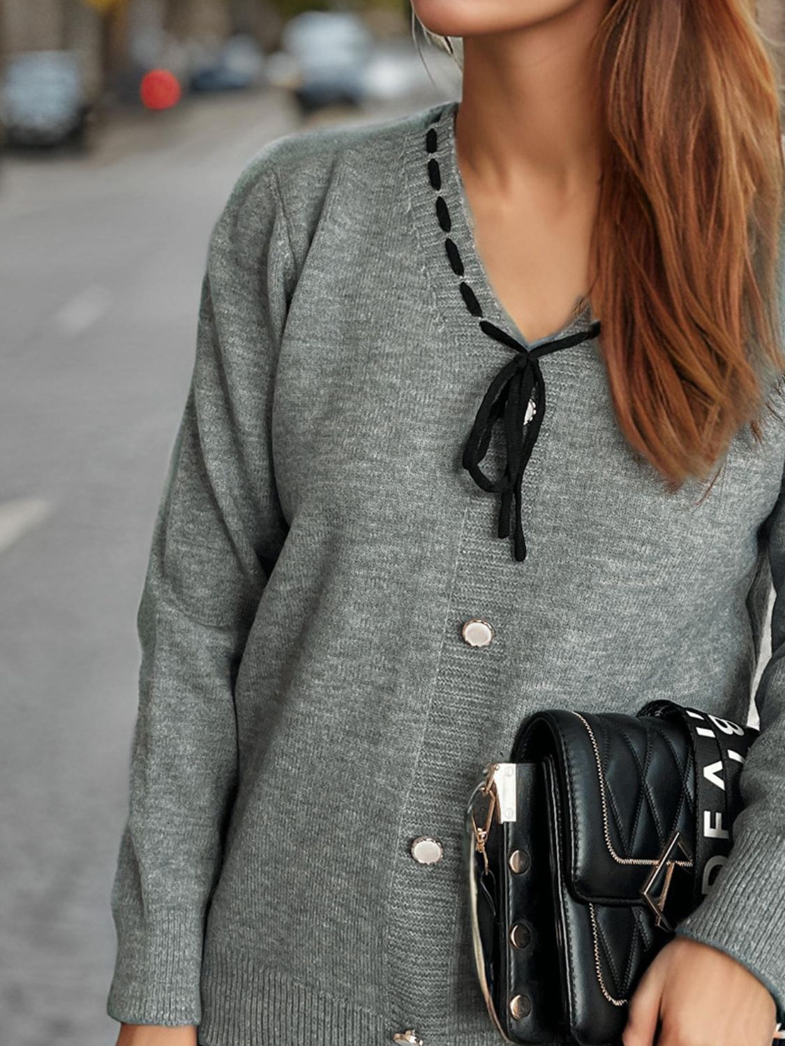 Gray knit cardigan with black ribbon trim and tie detail, button front, long sleeves.