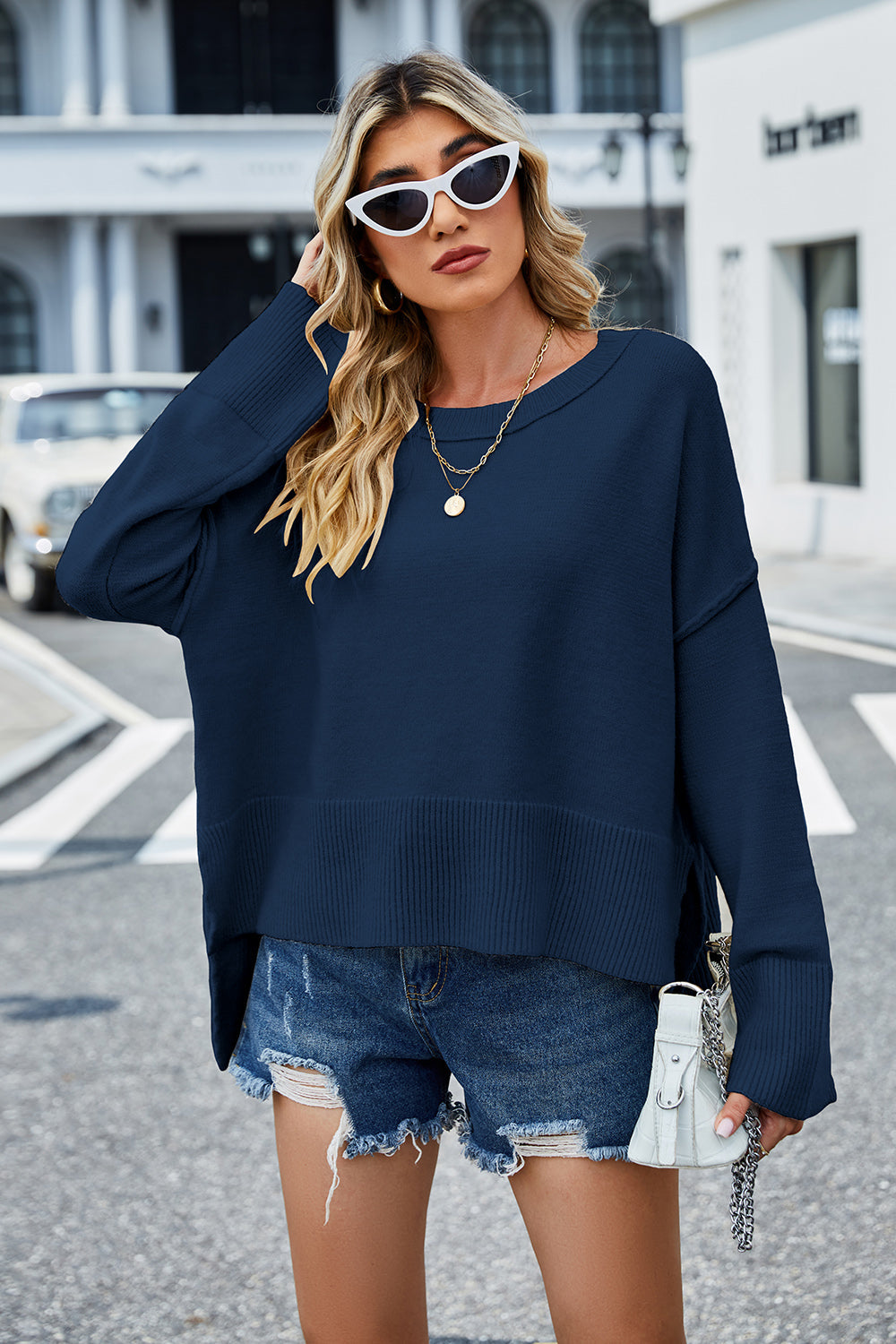 Peacock blue acrylic knit sweater with flared sleeves and split hem detail.