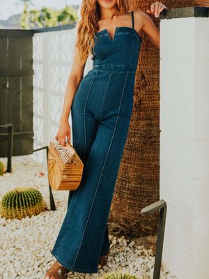 Denim jumpsuit with notched V-neck, wide legs, and contrast stitching.