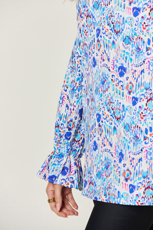 Blouse with abstract painterly print, gathered sleeves with ruffles, and blue tones.