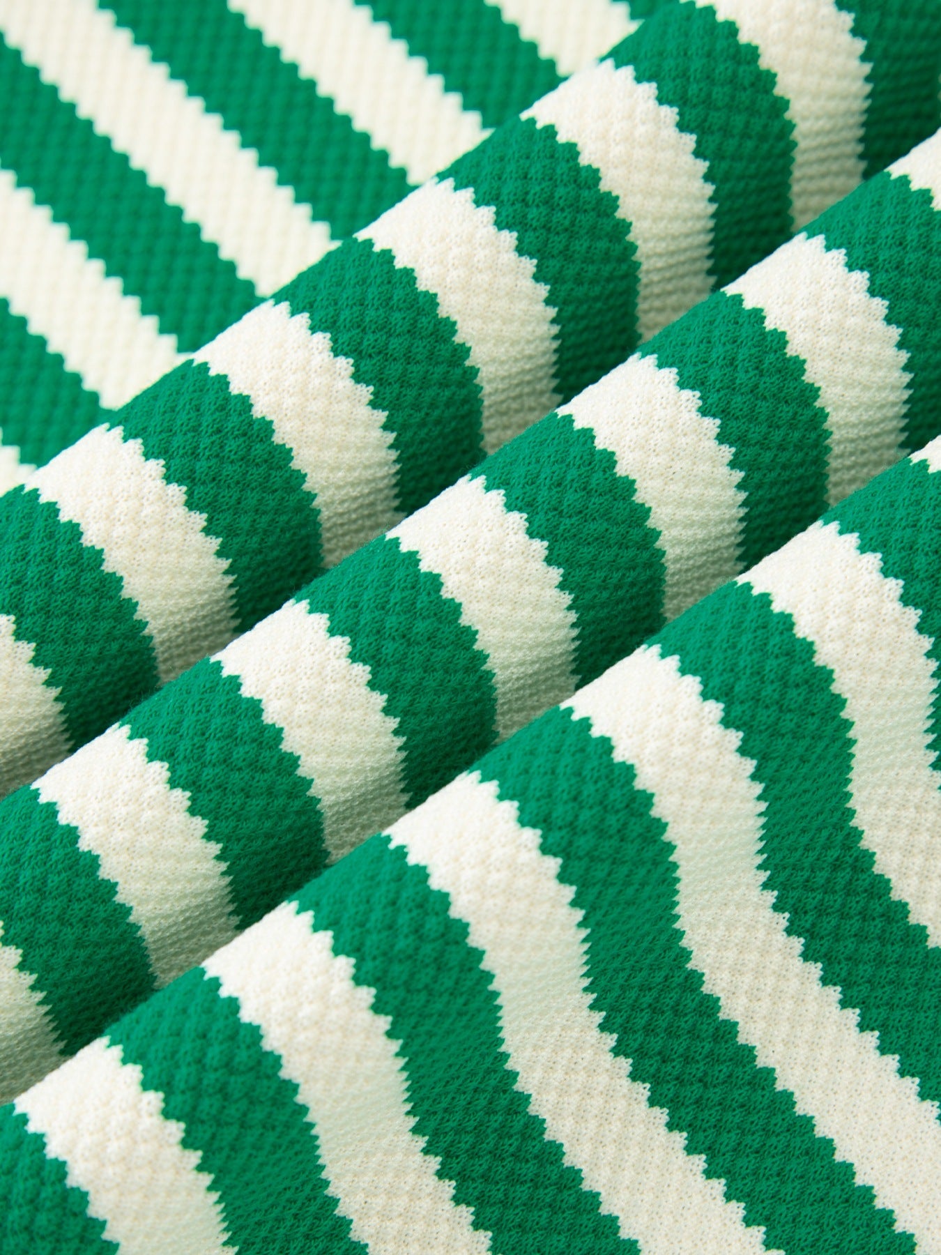 Green and white striped sweater with elastane, showing fabric texture.