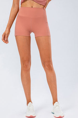 Sculpted performance shorts in coral with side pockets and a high waist.