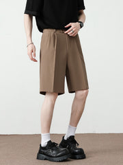 Men's light brown pleated detail loose-fit chino shorts with a relaxed cut.