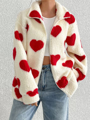 White sherpa zip-up jacket with red heart print and a collared neckline.