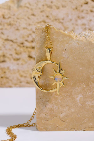 Gold celestial necklace with crescent moon face and starburst pendant