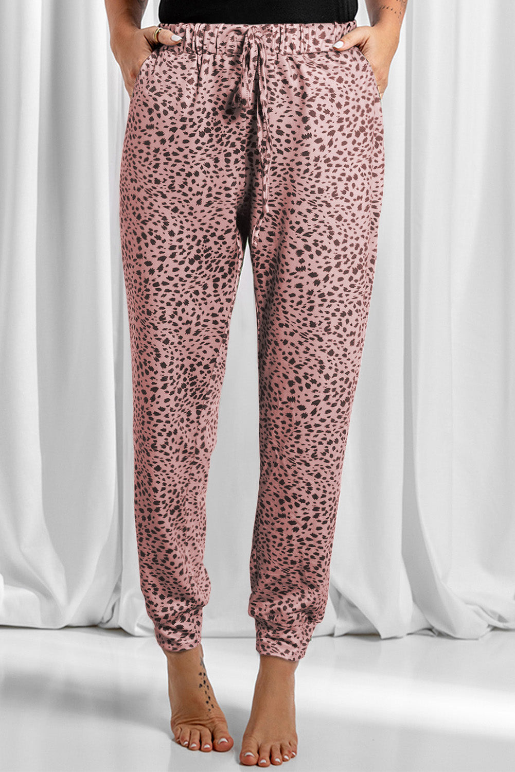 Dusty pink leopard print joggers with drawstring waist and cuffed ankles.