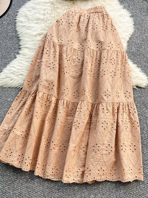 Apricot eyelet maxi skirt with tiered ruffles and elastic waistband.