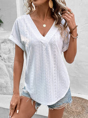 White eyelet V-neck tunic top with short sleeves and a curved hem.