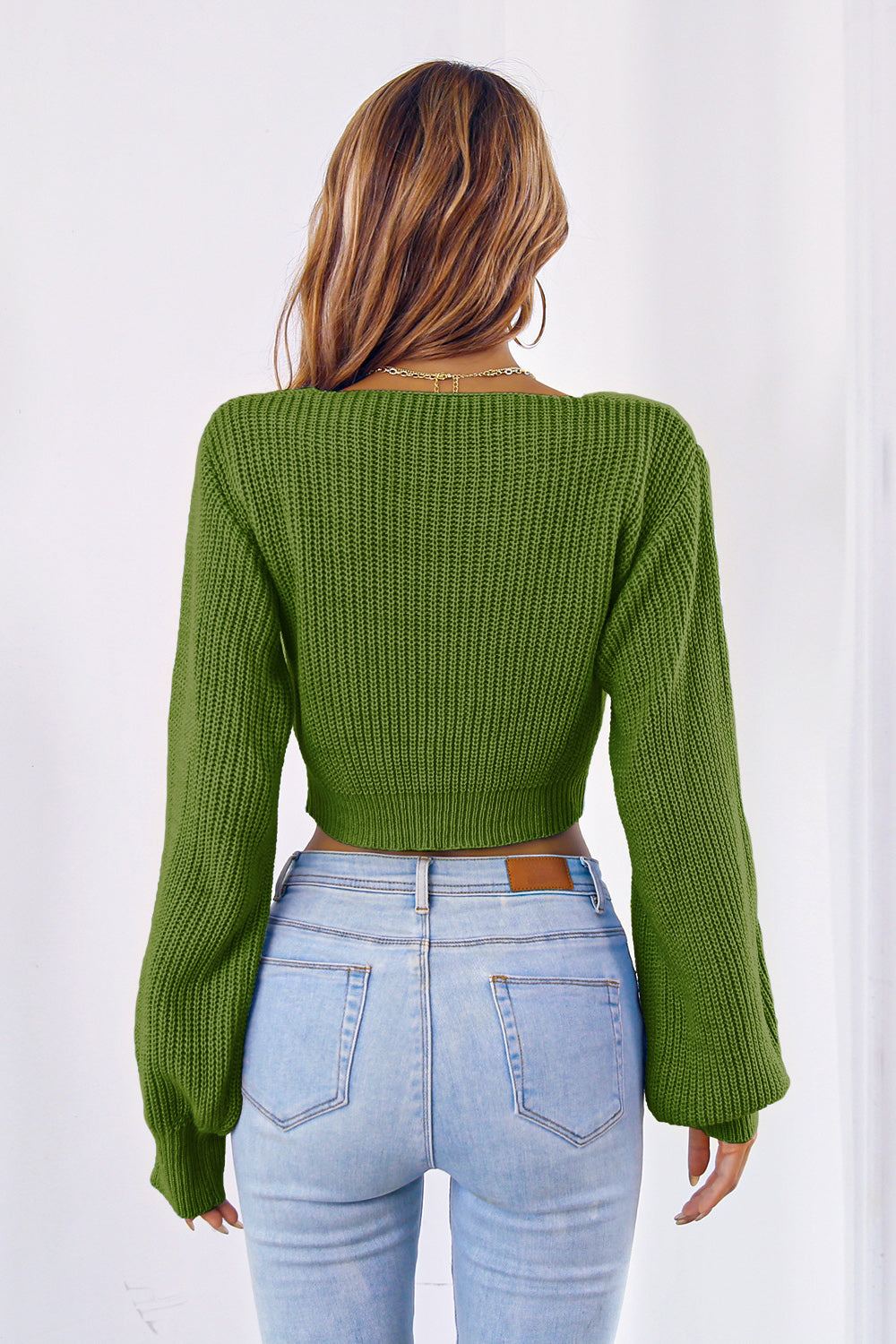 Green acrylic knit crop sweater with balloon sleeves and tie-front detail.