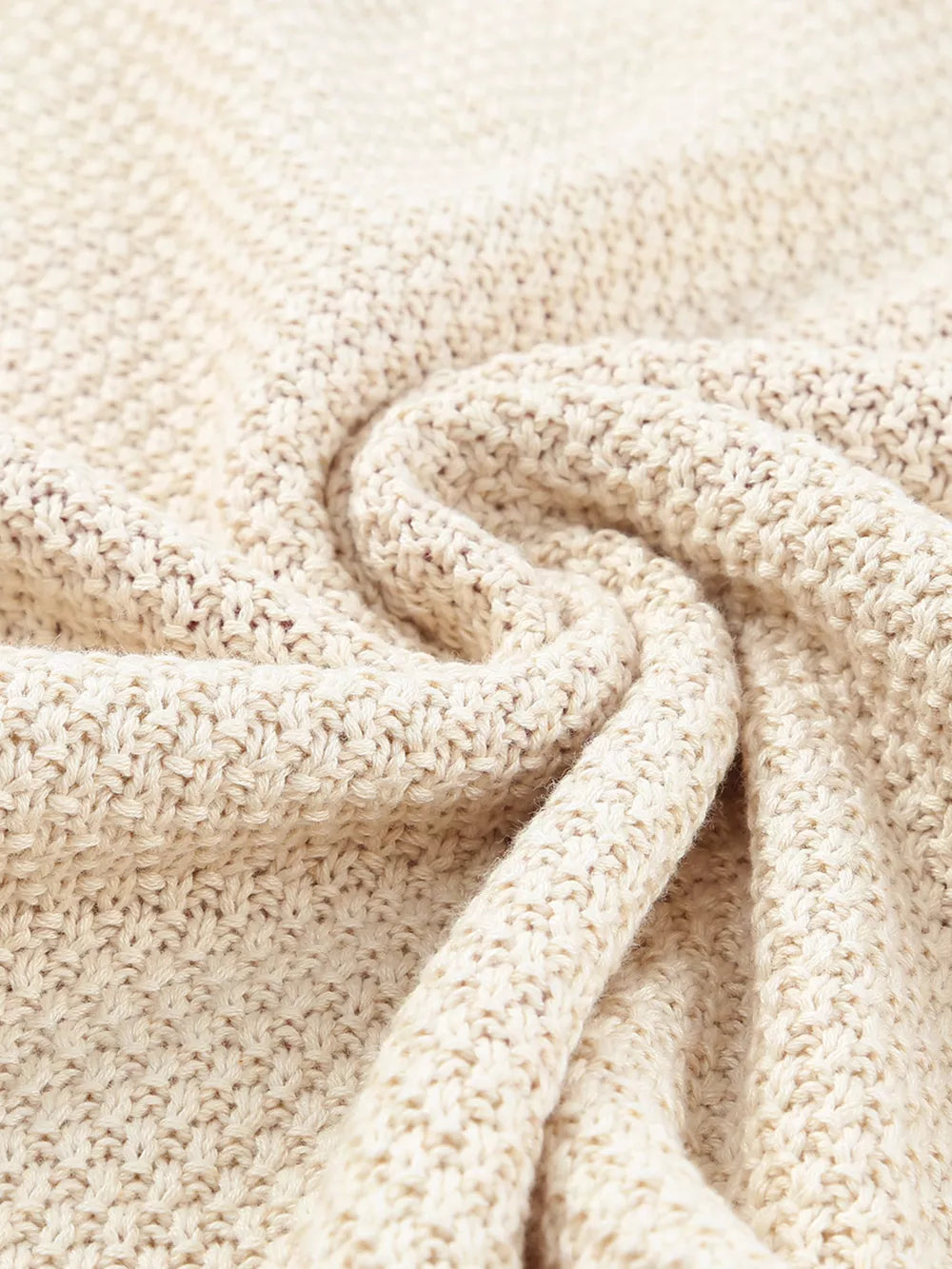 Beige knit sweater with a V-neck and subtle heart pattern, made of cotton and acrylic blend.