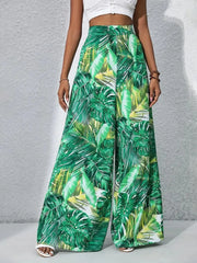 Green tropical leaf print palazzo trousers in 100% polyester with a wide leg