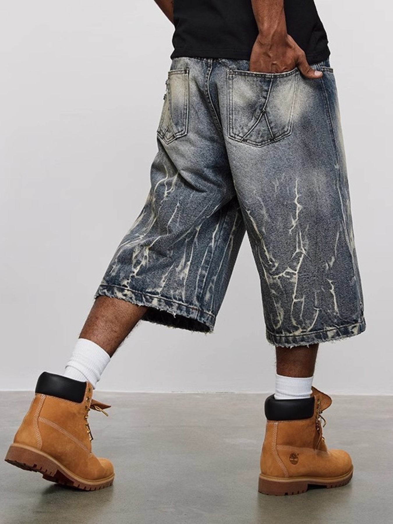 Men's loose fit denim shorts in blue with distressed wash and baggy cut.