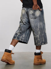 Men's loose fit denim shorts in blue with distressed wash and baggy cut.