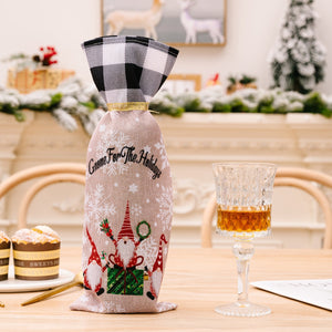 Gnome holiday wine bottle gift set with red and black buffalo check top and gnome and snowflake print.