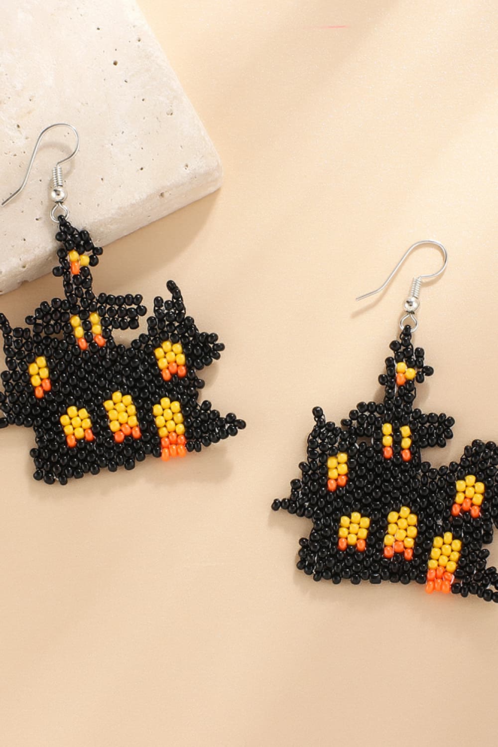 Beaded Castle earrings in black with orange and yellow accents.