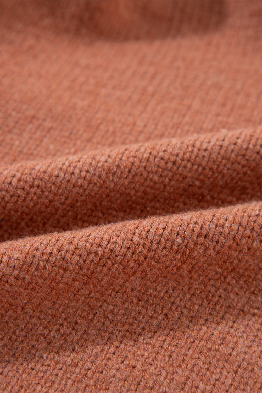 Open-front cropped knit cardigan in burnt coral acrylic with a ribbed texture.