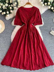 Crimson lace-embellished midi dress with V-neck, puff sleeves, and button detail.
