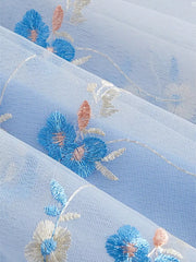 Blue mini dress with floral embroidery and tie shoulders.