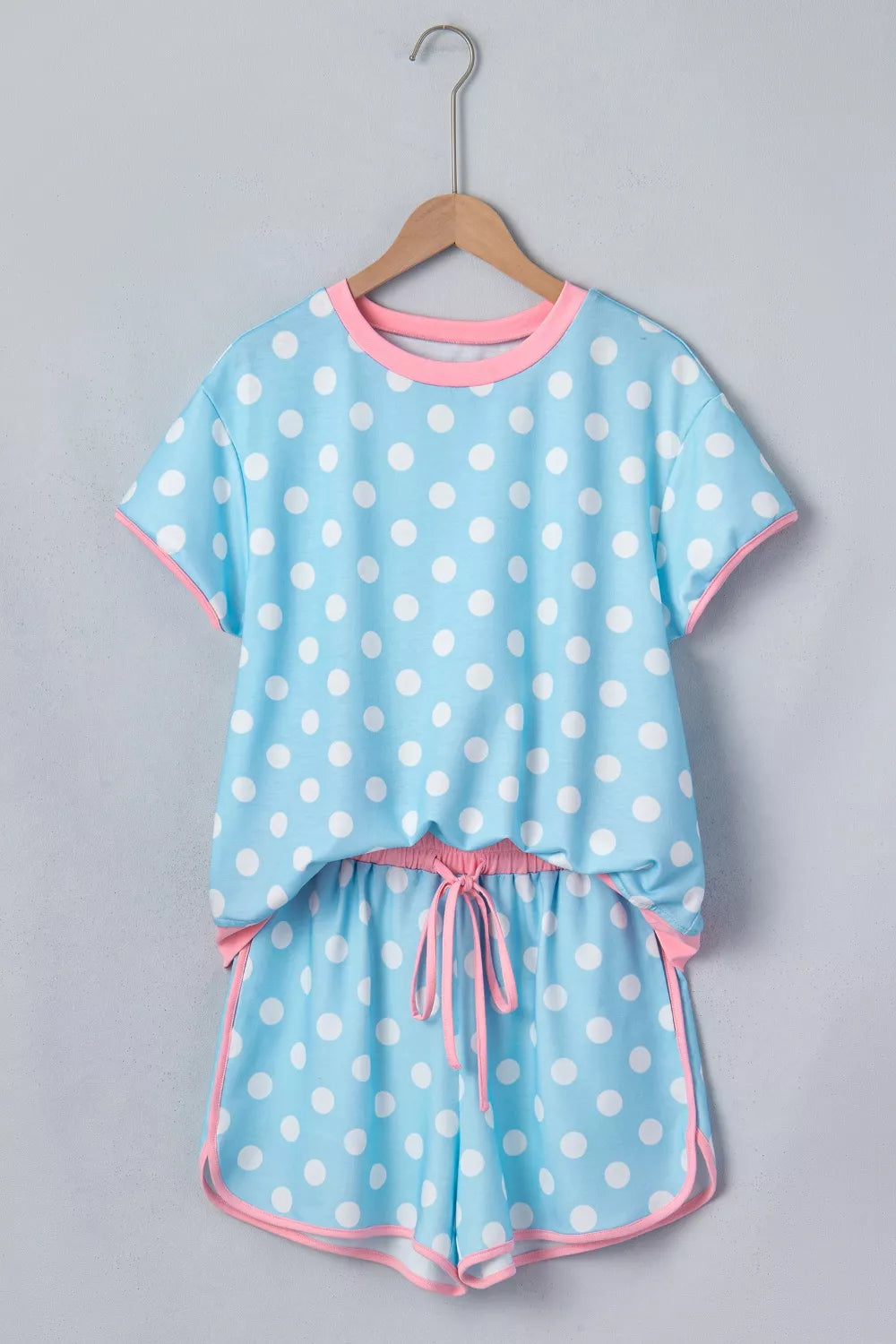 Pastel blue polka dot pajama set with pink trim and drawstring shorts.