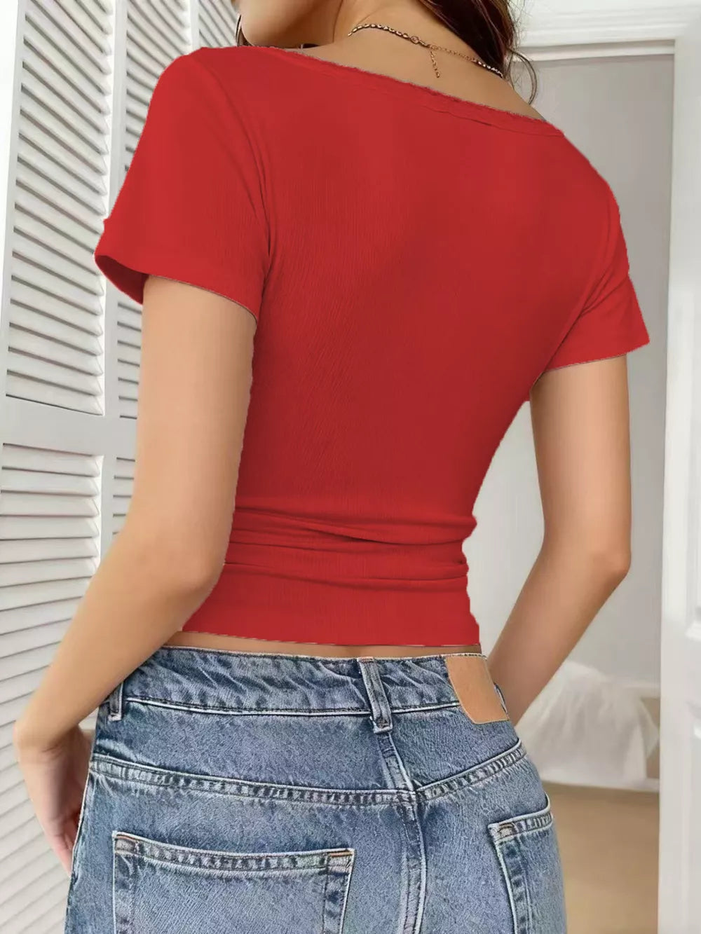 Red V-neck maternity shirt with short sleeves and lace trim detail.