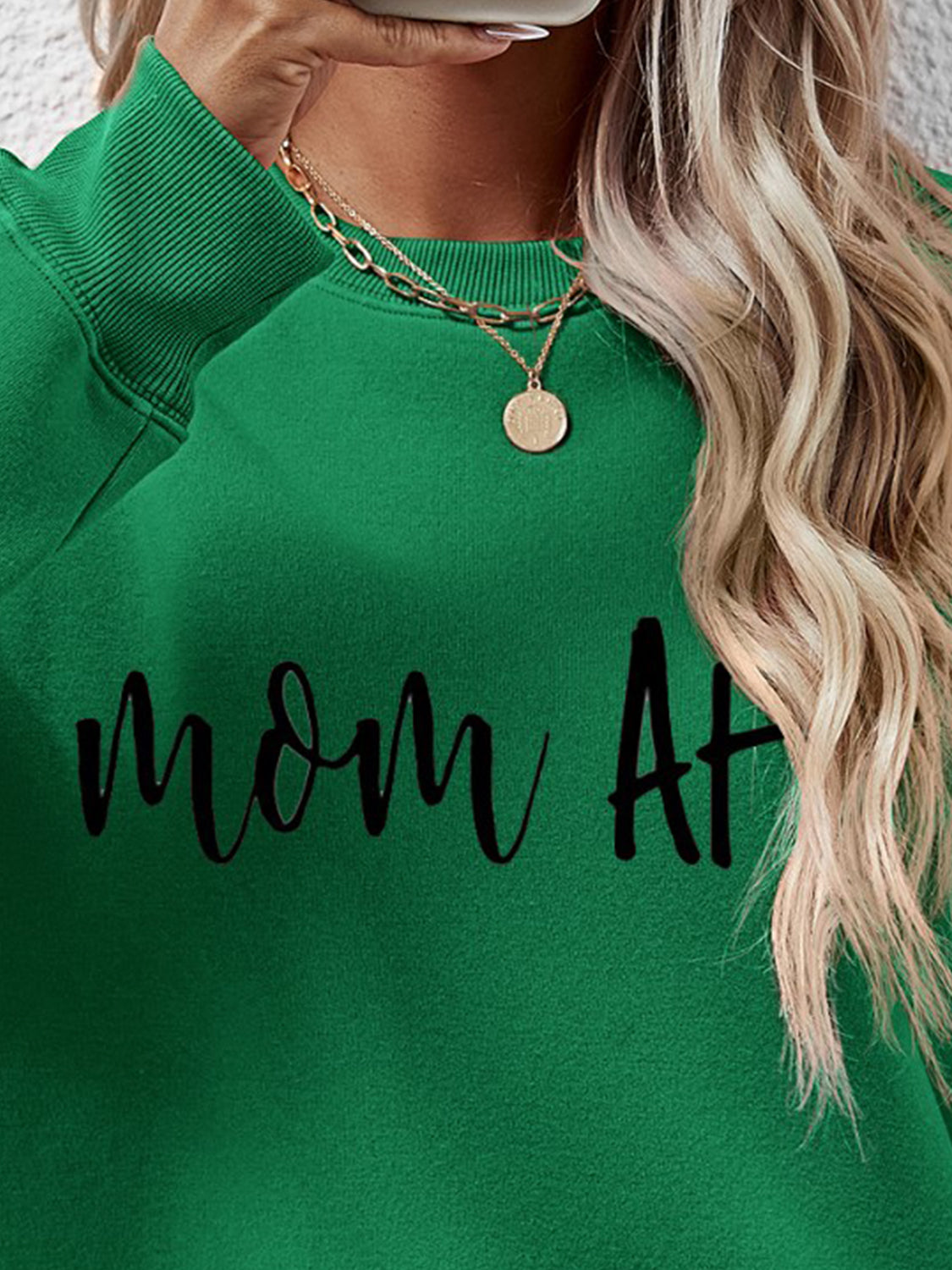 Green crewneck sweatshirt with black Mom At graphic and gold layered necklaces