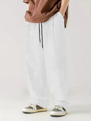 White corduroy relaxed fit trousers with drawstring waist and vertical texture.