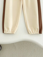Baby jogger pants in cream with brown side stripe and elastic cuffs.