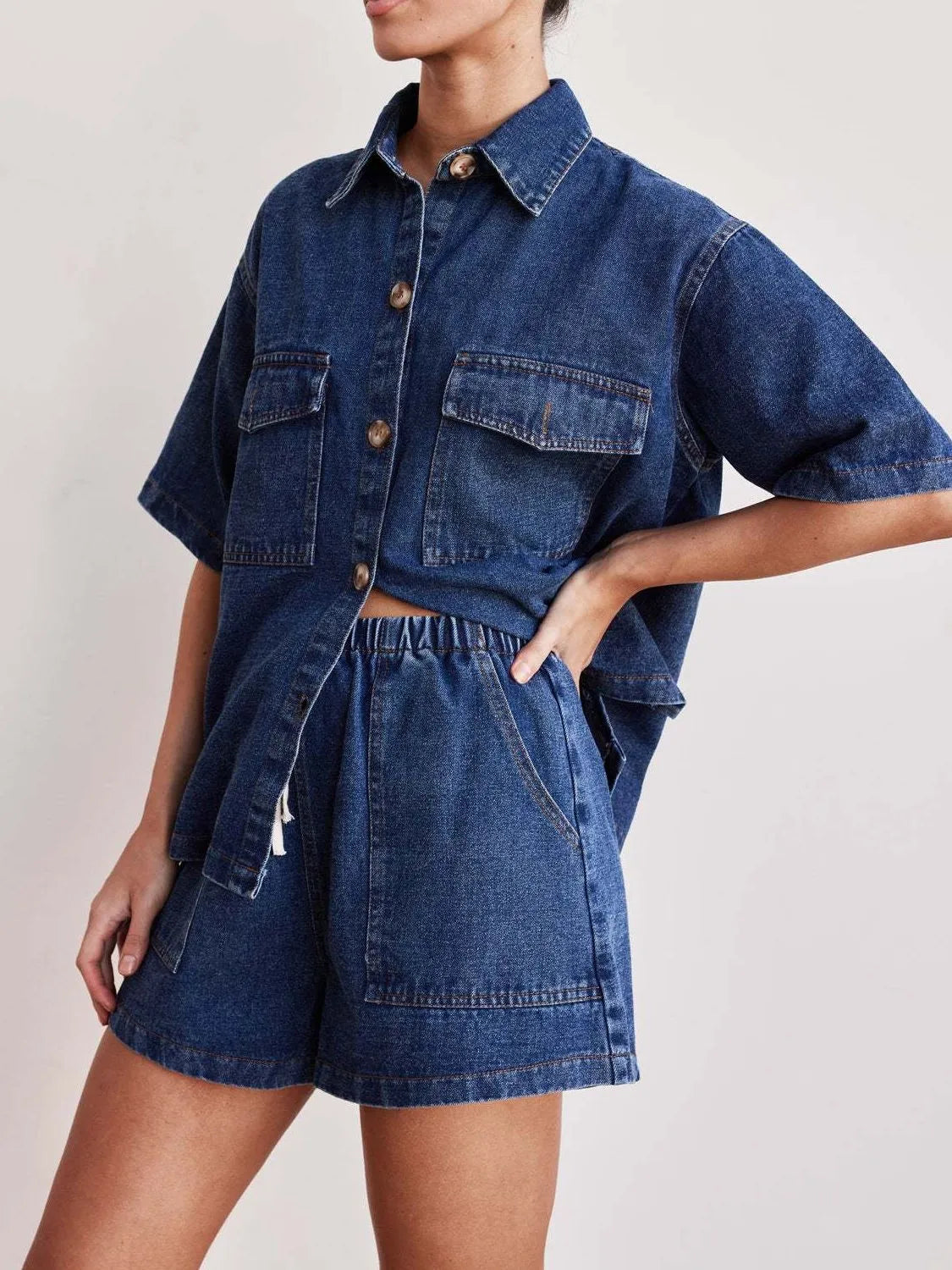 Medium wash denim co-ord set with short sleeve button-up shirt and elastic waist shorts.