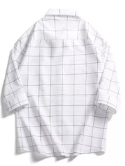White oversized cotton button-down shirt with black plaid print and collar.