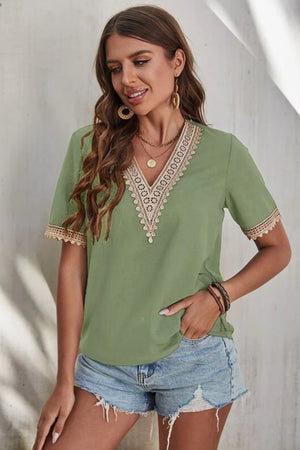 Light green V-neck blouse with lace trim on neckline and sleeves