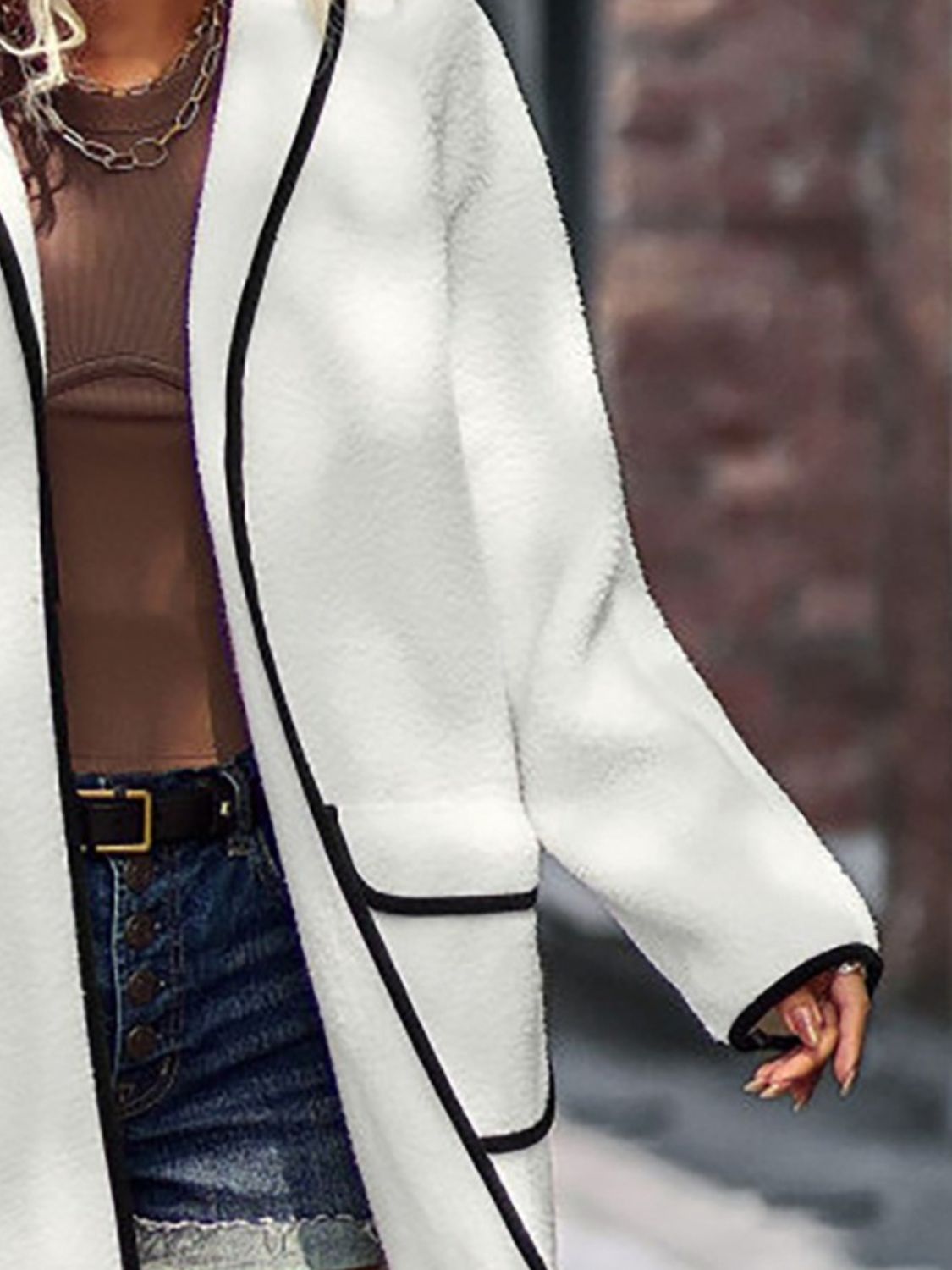 White teddy coat with black contrast trim detailing and pockets.
