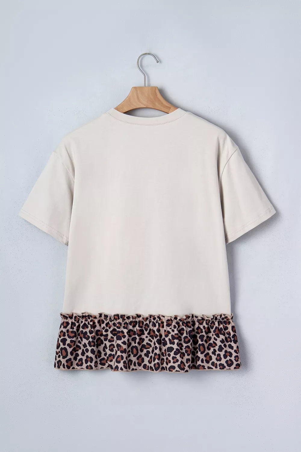 Cream cotton blend t-shirt with short sleeves and a ruffled leopard print hem.