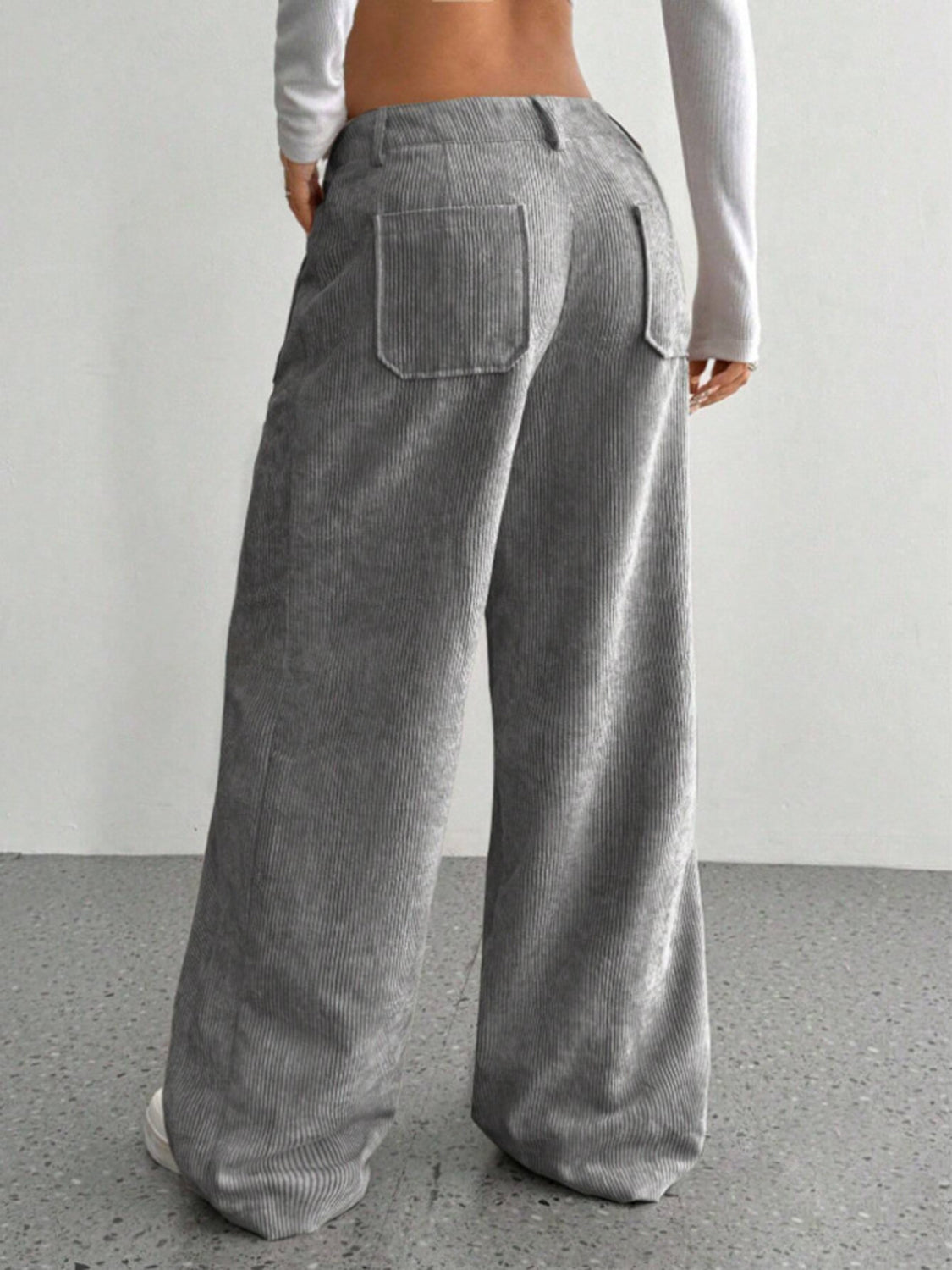 Gray corduroy wide-leg utility trousers with back patch pockets and a relaxed fit.