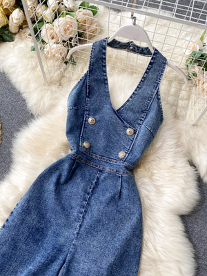 Blue denim halter neck wide-leg jumpsuit with double-breasted gold buttons.