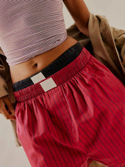 Scarlet boxer shorts with navy pinstripes and a black elastic waistband.