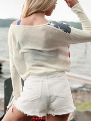 Ivory off-shoulder knit sweater with American flag detail on shoulder and sleeve.