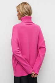 Oversized turtleneck knit sweater in vibrant hot pink with ribbed cuffs and hem.